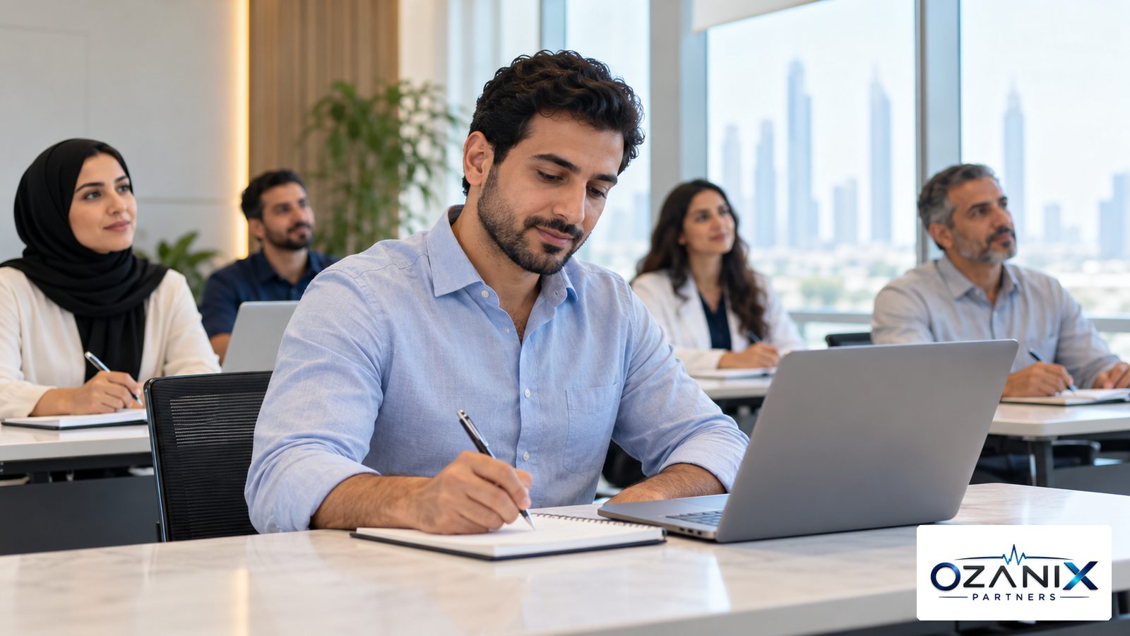 A doctor taking notes at a laptop during a professional training session in a bright conference room