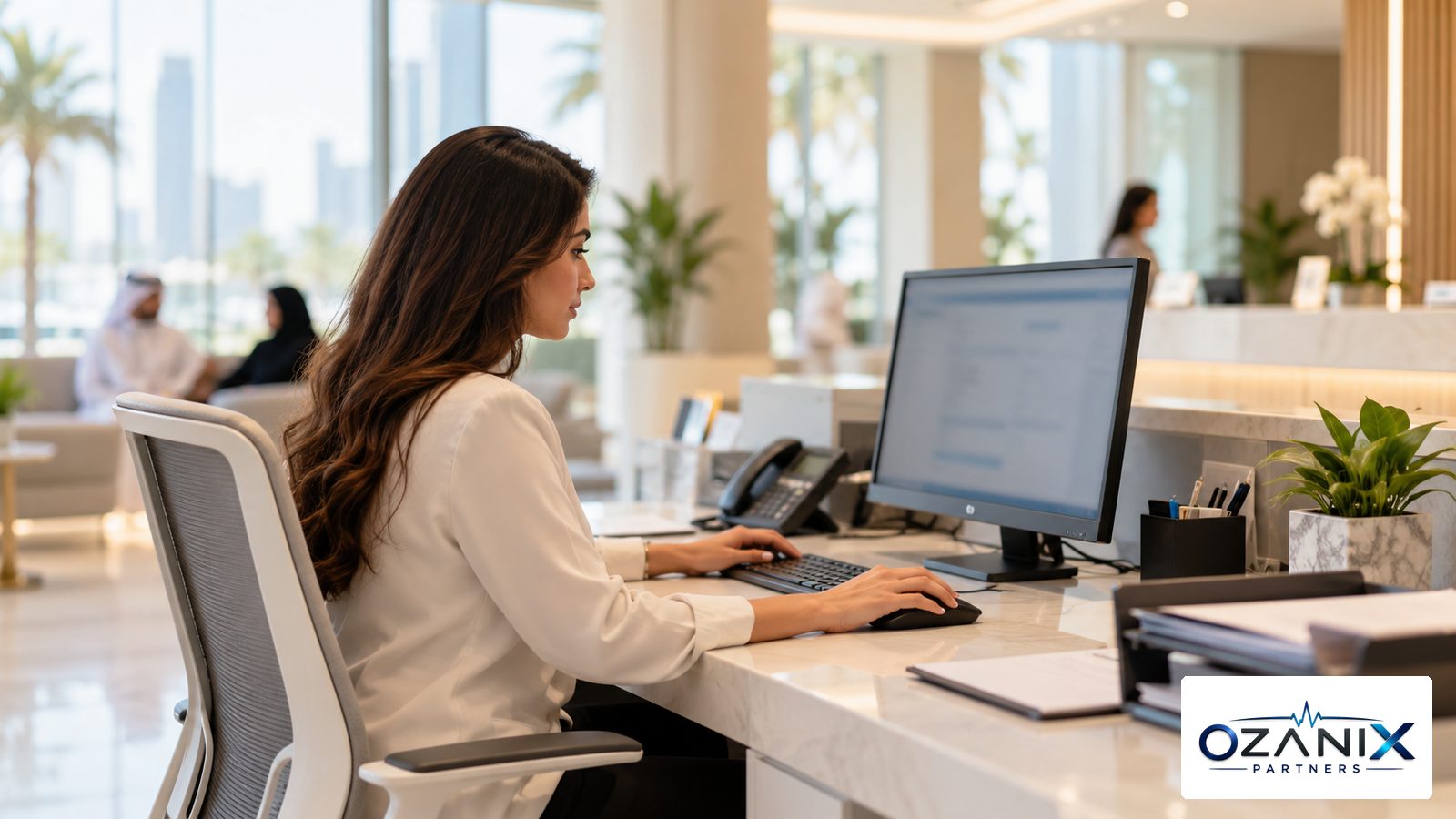 A billing coordinator working on insurance claims at a computer in a modern UAE clinic office